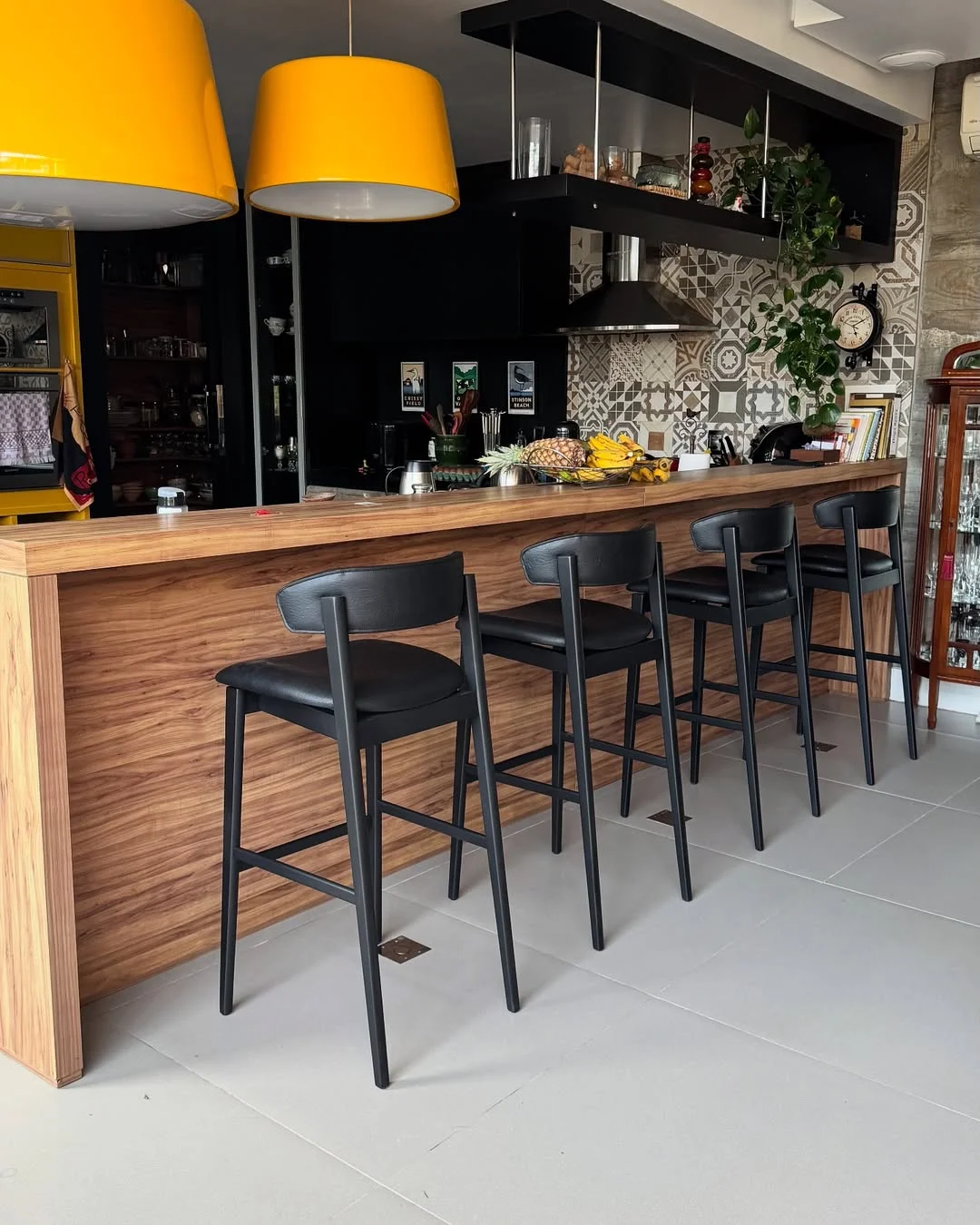 Banquetas pretas em bancada de madeira na cozinha